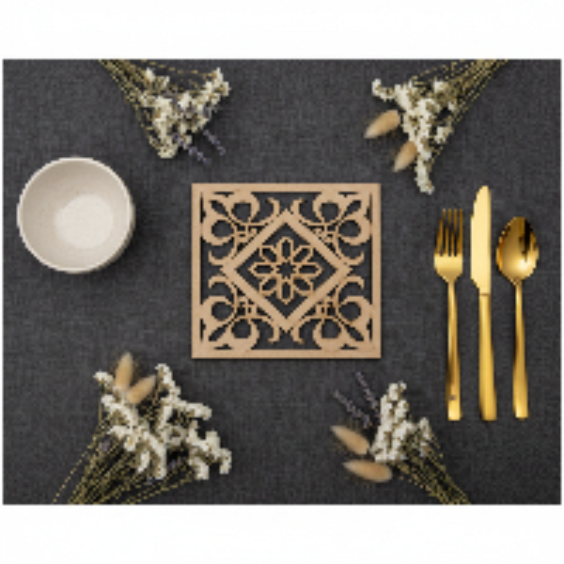 Flat lay de la Celosía Tawrīq sobre mantel oscuro con flores secas y cubertería dorada