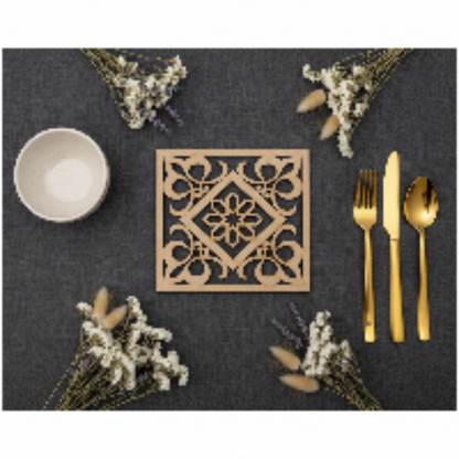 Flat lay de la Celosía Tawrīq sobre mantel oscuro con flores secas y cubertería dorada